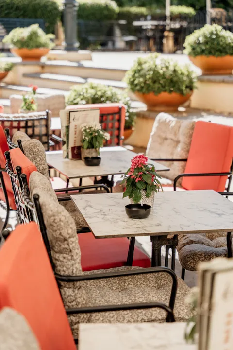 Καθιστικό με μαρμάρινα τραπέζια και κόκκινες καρέκλες